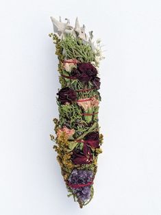 an arrangement of flowers arranged in the shape of a long tube on a white background