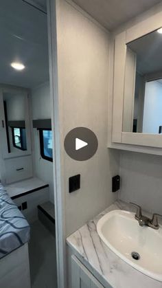 a white bathroom sink sitting next to a mirror and counter top in a room filled with furniture