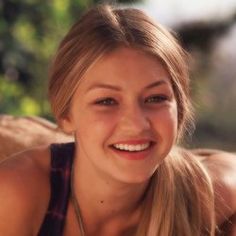 a woman with long blonde hair smiling at the camera