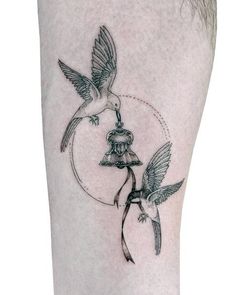 two birds flying over a bird feeder tattoo on the right side of the calf's leg