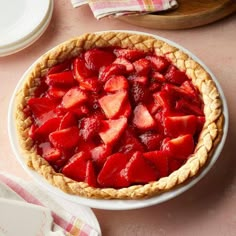 a pie with strawberries in it sitting on a table