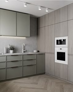 an empty kitchen with two ovens and some cupboards on the wall next to it