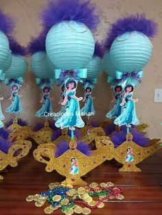 some blue and gold decorations on a table with paper lanterns in the shape of princesses