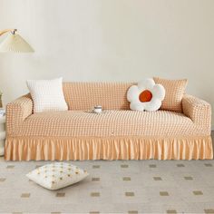 a living room with a couch, lamp and pillows on the floor in front of it