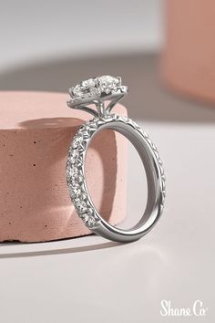 a diamond ring sitting on top of a pink cake