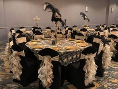 a banquet room set up with black and gold decorations