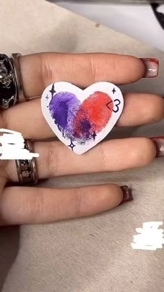 a woman's hand with red, purple and orange feathers on her ring finger