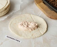 a tortilla with cream on it sitting next to other food items