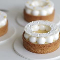 three small cakes with white frosting on them