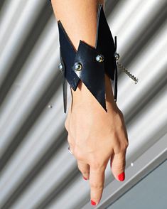 a woman's arm wearing a black leather bracelet