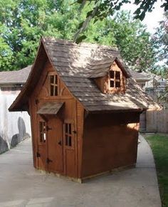 a small wooden house sitting on top of a sidewalk