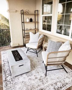 a living room with two chairs and a coffee table on top of a white rug