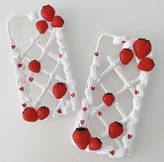 two cell phones made out of strawberries and white wire with red berries on them