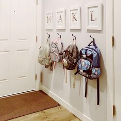 there are many backpacks hanging on the wall