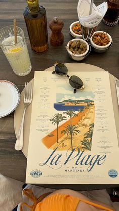 the table is set with food and drinks for two people to enjoy in la plage