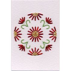 a white card with red and green flowers on it's side, in the middle of a circular design