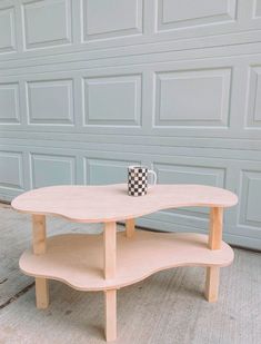 a coffee table with a checkered mug on it in front of a garage door