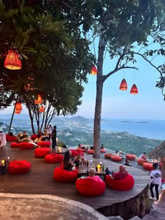 people are sitting on bean bag chairs at the top of a hill overlooking the ocean