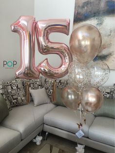 the number fifteen five balloons are in front of a couch