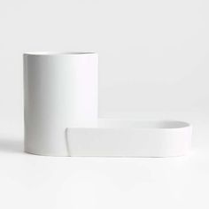 two white vases sitting next to each other on a white surface with one empty