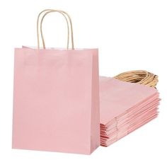 pink paper bags are stacked on top of each other with wicker handles and handles