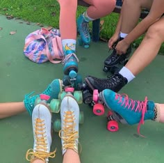 several people sitting on the ground with their feet on roller skates and one person is tying her shoes