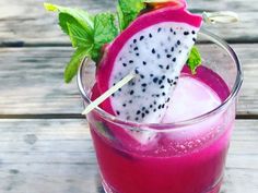 a glass filled with fruit and ice on top of a wooden table