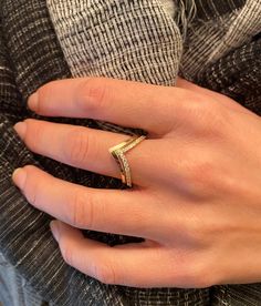 a woman's hand with a gold ring on her left and a diamond in the middle