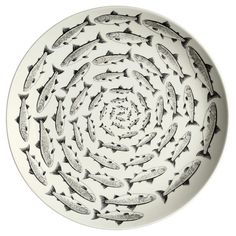 a white plate topped with lots of black and white fish on it's side