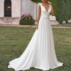 a woman in a wedding dress standing on the grass