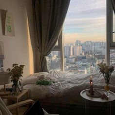 a bedroom with a large window overlooking the city