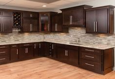 an empty kitchen with wooden cabinets and marble counter tops in the middle of the room