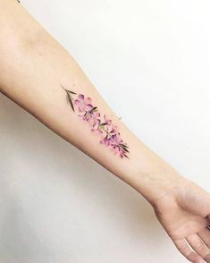 a woman's arm with pink flowers on the left side of her body and an arrow in the middle