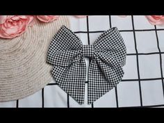 a black and white bow tie sitting on top of a table next to pink flowers