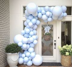 the balloon arch is decorated with blue and white balloons