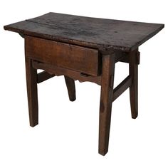 an old wooden table with one drawer on the top and two legs at the bottom