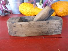 an old wooden box with two knives in it sitting on a table next to other metal containers