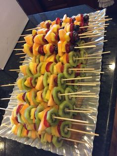 several skewers of fruit are arranged on a sheet of tin foil