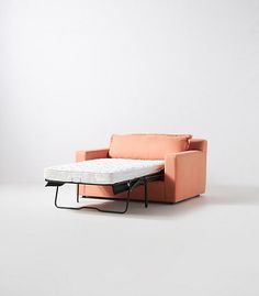 an orange couch with a mattress on it