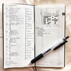 an open notebook with crosswords and a pen