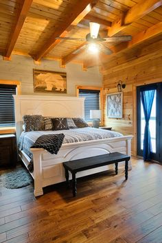 a large bed sitting inside of a bedroom on top of a hard wood floor