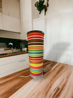 a colorful cup sitting on top of a wooden table