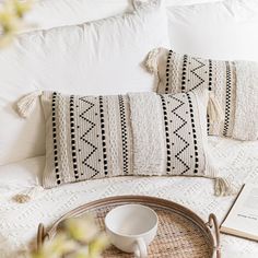 a tray with a book, coffee cup and two pillows sitting on top of a bed