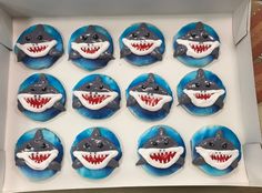 twelve cupcakes in the shape of sharks with teeth