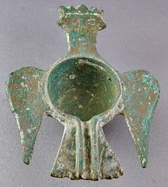 an old green metal object with wings on it's back and the top part of its body