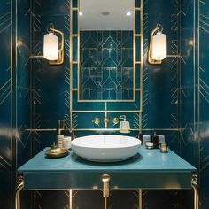 a bathroom with blue walls and gold trimmings on the mirror above the sink