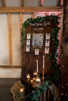 candles are lit in front of a wood paneled sign that reads find your seat