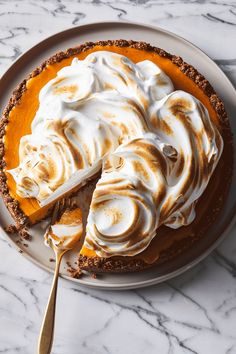 there is a pie with whipped cream on it and a fork in the plate next to it