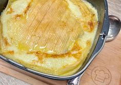 an omelet in a pan on a wooden cutting board