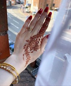 a woman's hand painted with henna on the side of a building next to a street